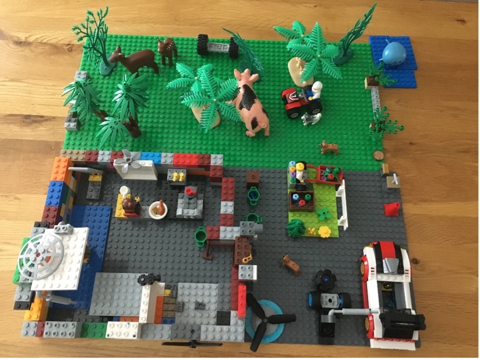A photograph of a landscape made of lego bricks showing a sustainable home designed by a school pupil