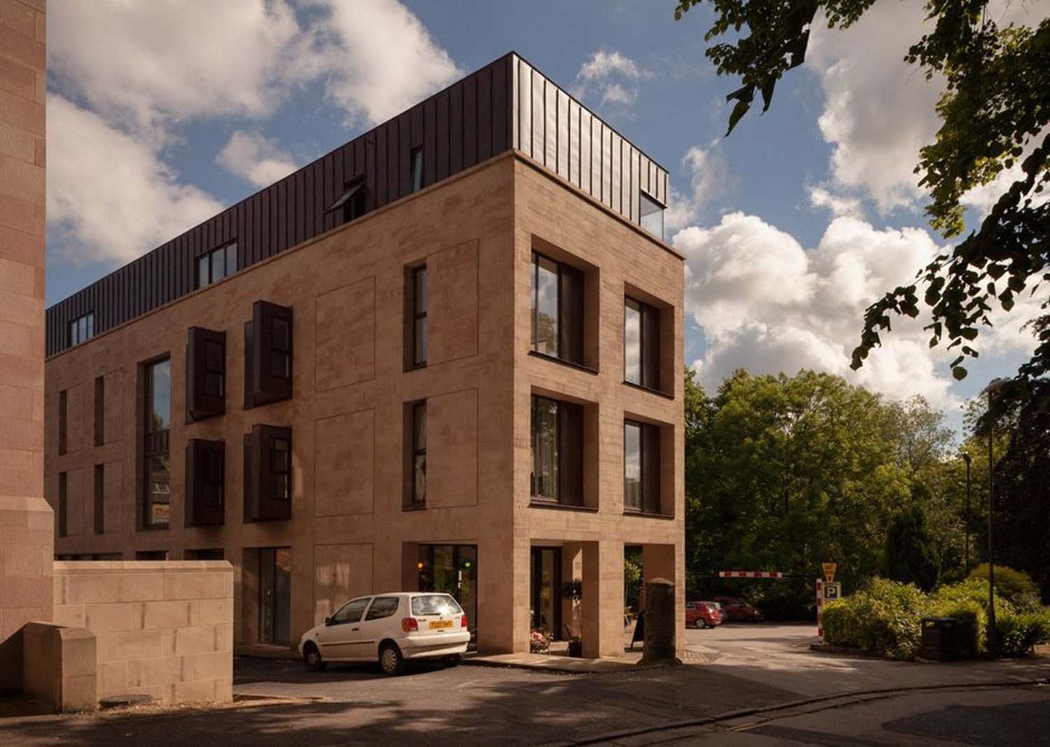 A four-storey apartment building at Matlock, Derbyshire, has a sandstone façade except for the fourth floor.