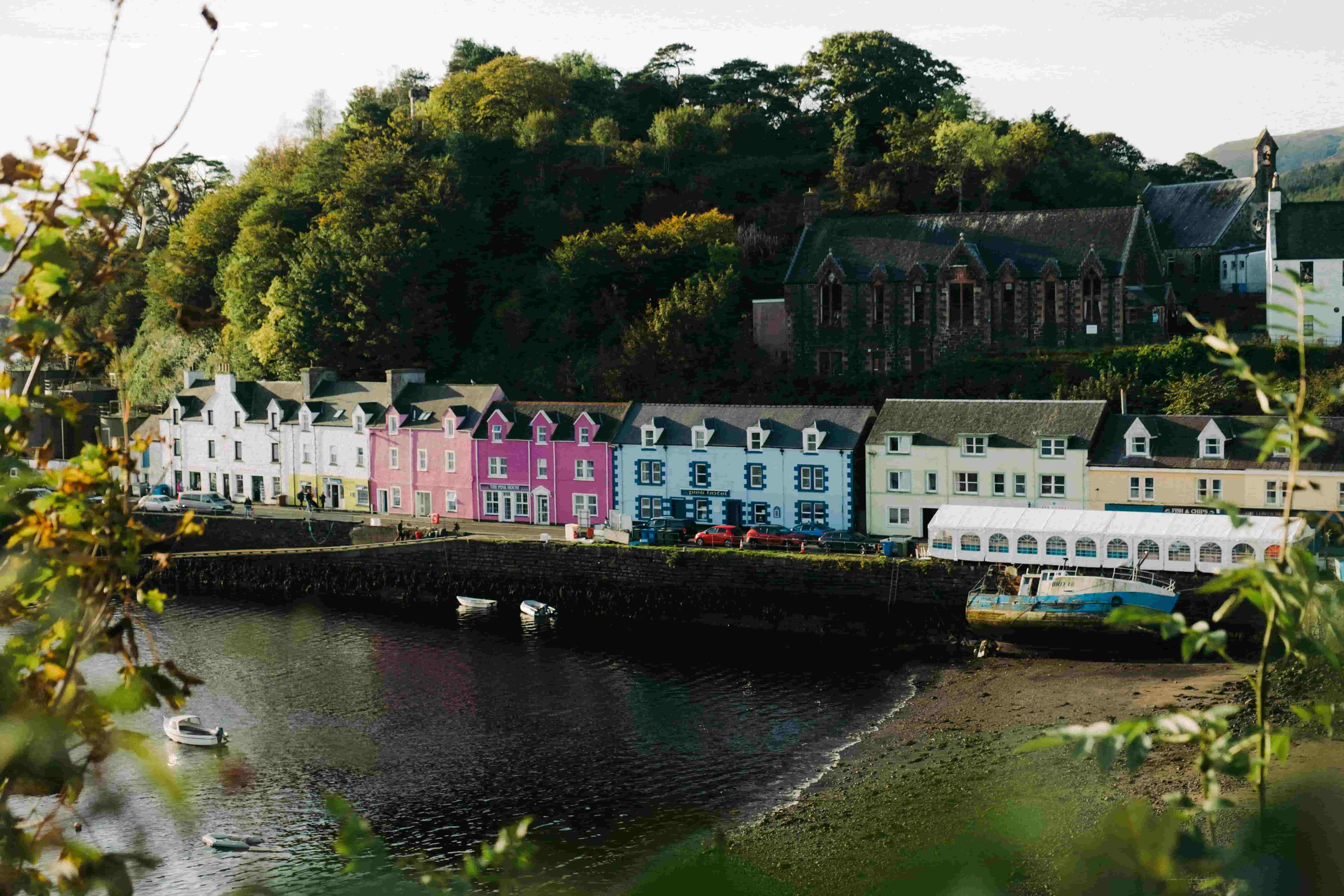 A view of a row of multi-coloured buildings in a harbour in Portree, Skye.