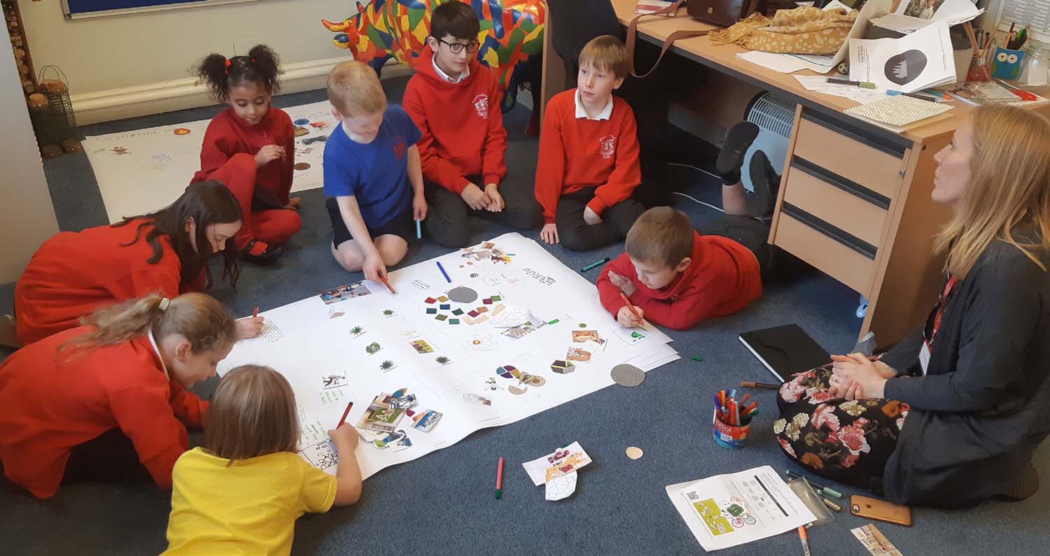 Corstorphine Primary School pupils creating a collage and discussing how they would like to use a space with a teacher. 