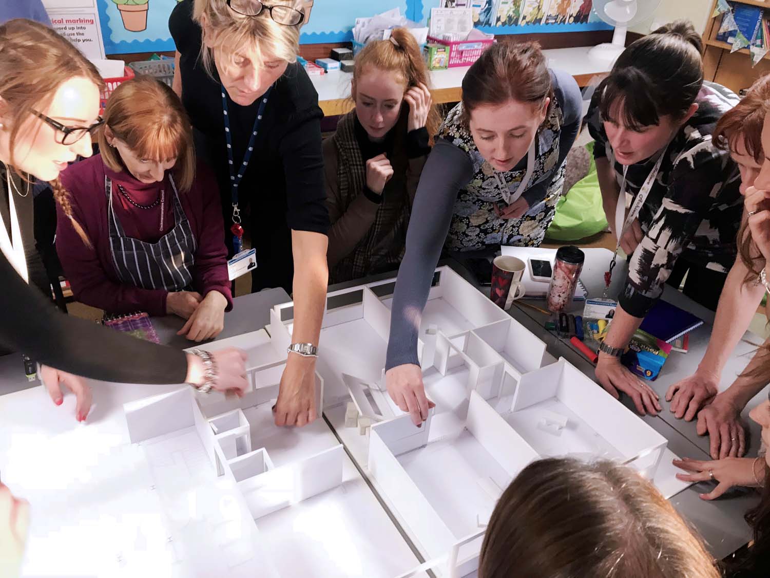  Teachers discussing a model floorplan of their school during a Tests of Change workshop.