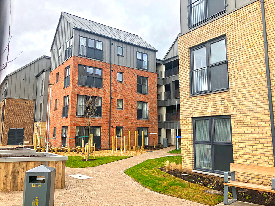 Four story housing development with gardens, raised beds and aseating area.