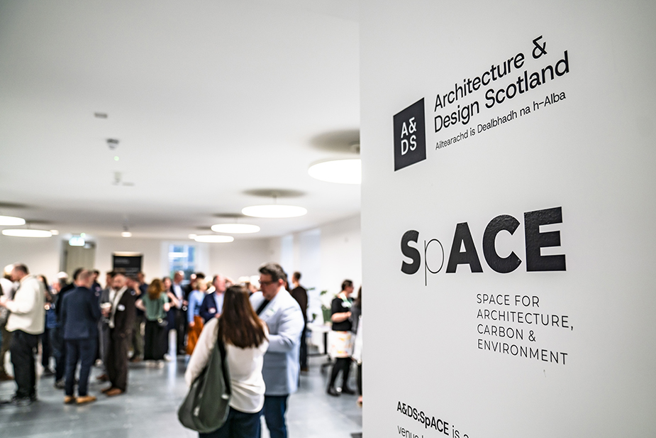 A&DS:SpACE logo on a pillar with people in the background.